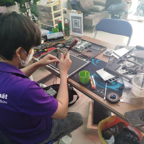 Hình ảnh một kỹ thuật viên đang sửa chữa mainboard laptop với các dụng cụ chuyên nghiệp.